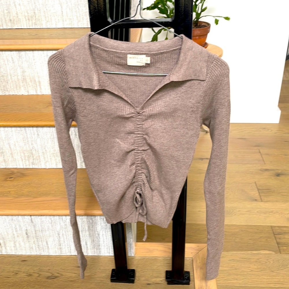 Ribbed sweater with pull tie front. Runs small